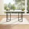 Laiendatav söögilaud metallraamiga, valge-must 140–180 cm | E-pood Tootemaailm Valge-must laiendatav söögilaud metallraamiga, asub avaras valgusküllases ruumis suure akna ees. Laud on osaliselt kaetud väikese taime ja puuviljakausiga.