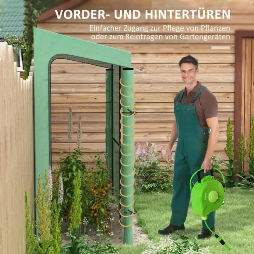 Kasvuhoone UV-kaitsega kahe ukse ja aknaga 200x80x200 | E-pood Tootemaailm Metsaroheline kasvuhoone UV-kaitsega, mis on avatud kahe uksega, ja selle sees on lopsakad taimed. Paremal pool seisab mees sinakasrohelises tööriietuses, hoides kastmisvoolikut, taustal on puidust ait.