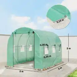 Roheline polüetüleenist kasvuhoone tunnel, mõõtmetega 3x2x2 m, koos kahe ukse ja mitme aknaga ventileerimiseks, alusel kividega kaalutatud, paiknedes aiaplatvormil selge sinise taeva taustal.