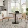 Ümmargune söögilaud tammepuidu imitatsiooniga 120 cm | E-pood Tootemaailm Ümmargune söögilaud tammepuidu imitatsiooniga 120 cm, must jalg, õhulise ja valgusküllase köögi interjööris modernsete korvmaterjalist toolidega.