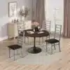 Ümmargune söögilaud tammepuidu imitatsiooniga 120 cm | E-pood Tootemaailm Stiilne ümmargune söögilaud 120 cm, tammepuidu imitatsiooniga, paigutatud heledale puidust põrandale avaras elutoas. Laua ümber asuvad neli modernse disainiga halli tooli mustade istmetega. Taustal on suur aken ja hele kardin, mis annab ruumile avarust ja valgust.