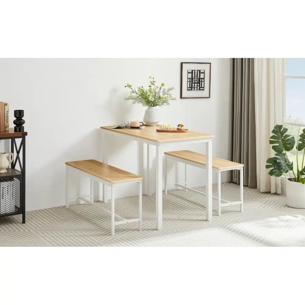 Minimalistlik köögimööbel puidust lauaplaadiga söögilauad pinkidega 110x60x75cm, millel on valged metallraamid. Taustal heledate seinte ja rohelise taimega kaasaegne interjöör.