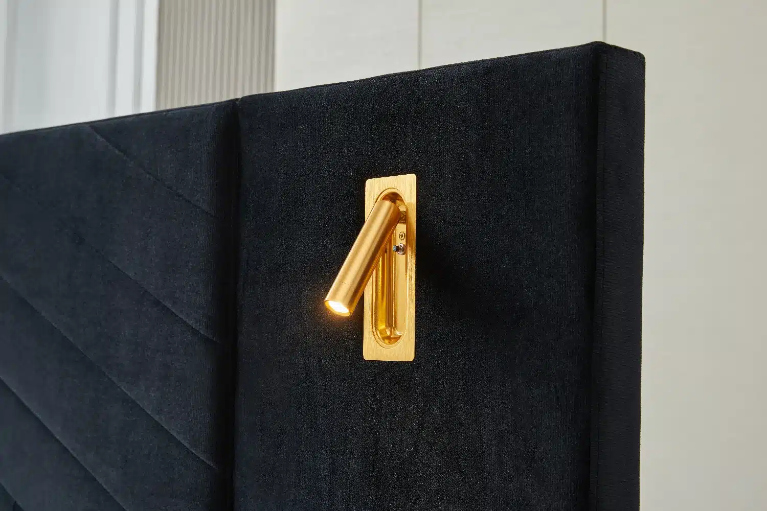Kvaliteetse voodi elegantne must seljatugi sisseehitatud kuldse LED valgustiga, mis lisab luksuslikku atmosfääri magamistuppa.