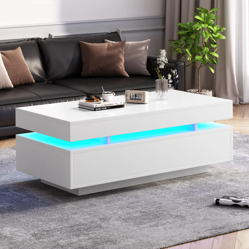 Elegantne diivanilaud LED-valgustusega, valge kõrgläikega pinnaga, kaks praktilist sahtlit, asub kaasaegses elutoas musta diivani ees hallil vaibal.