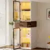 Vitriinkapp LED-valgustusega, 2 ust, 1 sahtel heledas elutoas, taustal valged ribakardinad ja toataim.