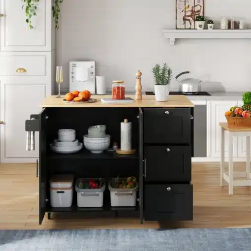Köögikapp ratastel, kokkupandav, 3 sahtliga, 135 cm | E-pood Tootemaailm Elegantne must köögikapp ratastel, kokkupandav ja 3 sahtliga, 135 cm, paistab helges köögikeskkonnas. Kapil on hele puidust tööpind, millest vasakul on näha veiniklaas ja erinevad tarvikud kappide kõrval. Mitmed rohelised toataimed ja köögitarvikud taustal lisavad mugavust.