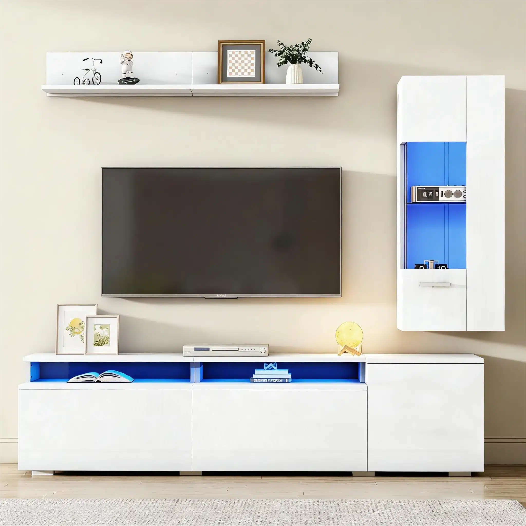 TV-elutoa komplekt LED-valgustusega, valge kõrgläige. Komplekt koosneb kapist, riiulist ja seinakapist kaasaegses elutoas, mille taustal on hele sein. Kapi ülaosas on LED-valgustus sinise tooniga, mis rõhutab luksuslikku kujundust.