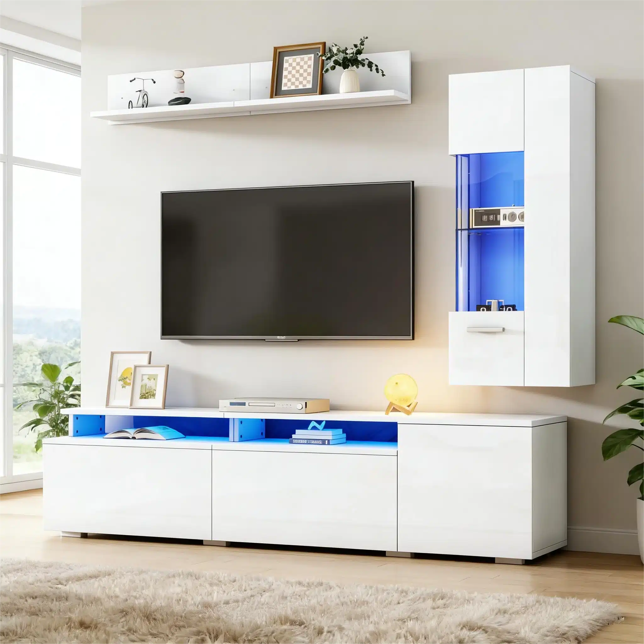 Stiilne TV-elutoa komplekt LED-valgustusega, valge kõrgläige. Komplekt koosneb modernsest kapist ja seinaläbist, millel on sinised LED-valguslahendused. Mööbel on paigutatud helgesse elutuppa, mille taustal on hele vaip ja roheline taim.