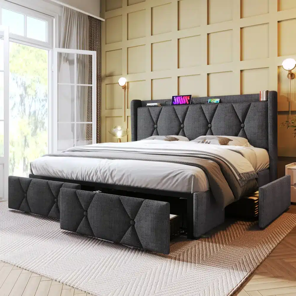 Elegantne panipaigaga voodi 160x200 hallis toonis, varustatud USB laadijaga ja nelja praktilise sahtliga. Voodi paikneb hubases magamistoas, rikkaliku paneelseina ja suurte akende taustal.