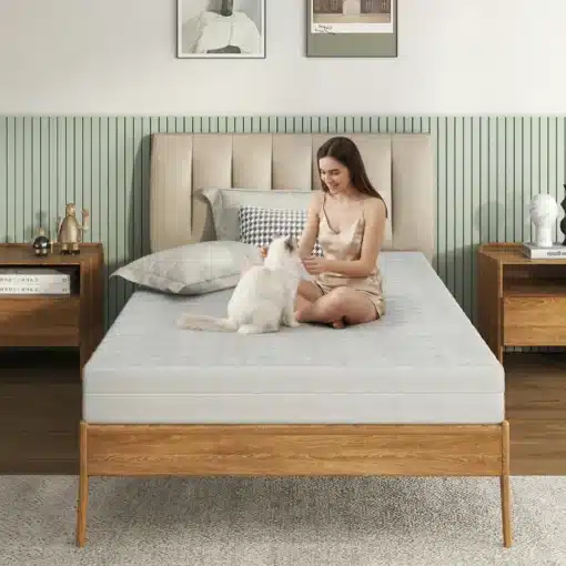 Ortopeediline vahtmadrats 120x200cm 3D õhulise kattega | E-pood Tootemaailm Naine istub hubases magamistoas Ortopeedilisel vahtmadratsil 120x200cm 3D õhulise kattega, hellitades valget kassi. Madratsi neutraalne värv sulandub stiilse puidust voodiraamiga, taustal pehmed padjad ja öökapp.