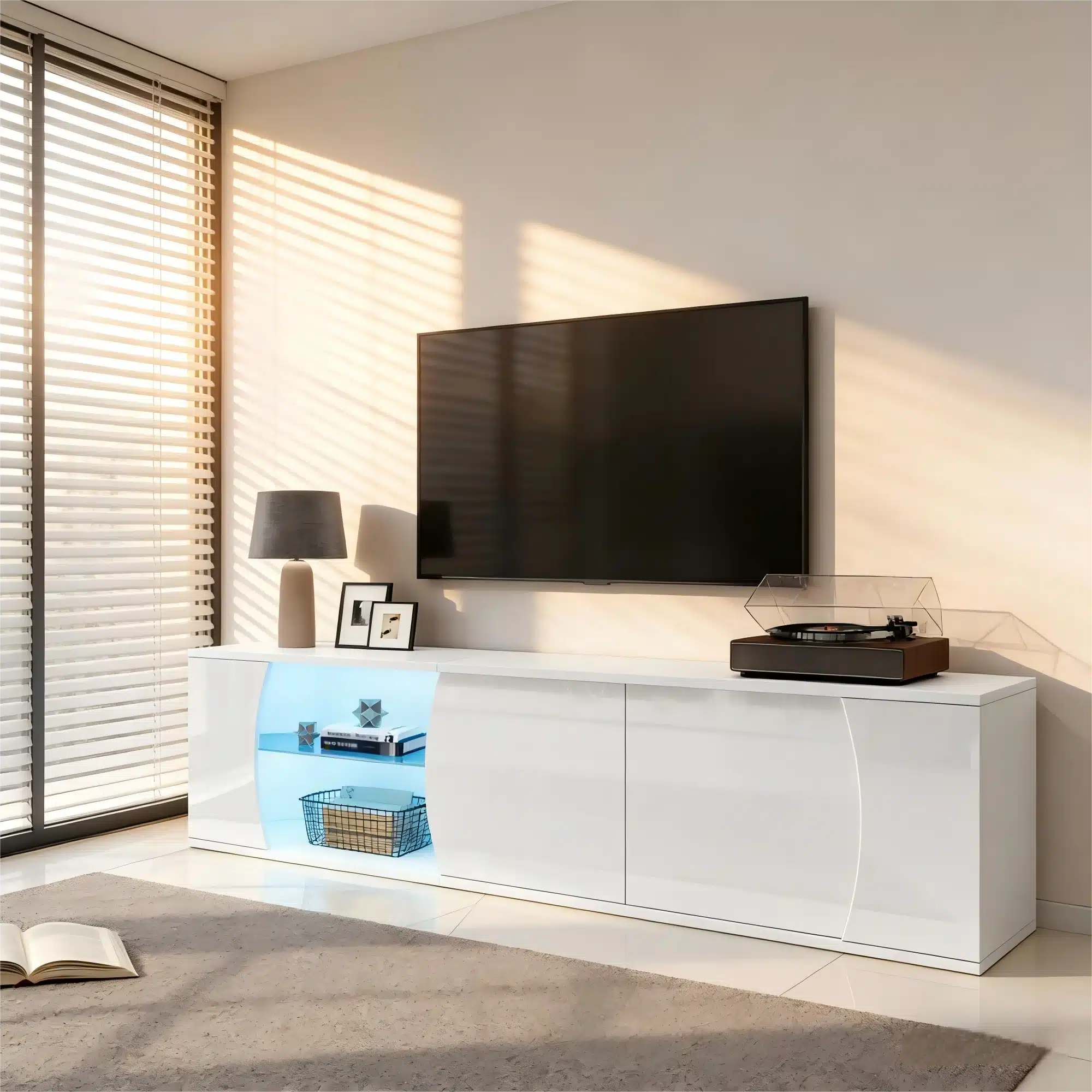 Elegantne TV-alus LED-valgustusega, karastatud klaas, 180 cm, asetatud valgusküllasesse elutuppa. Alusel on kaasaegne disain koos raamaturiiuli ja korviga, valge värvi ja läikiva viimistlusega, mis täiustavad ruumi interjööri.