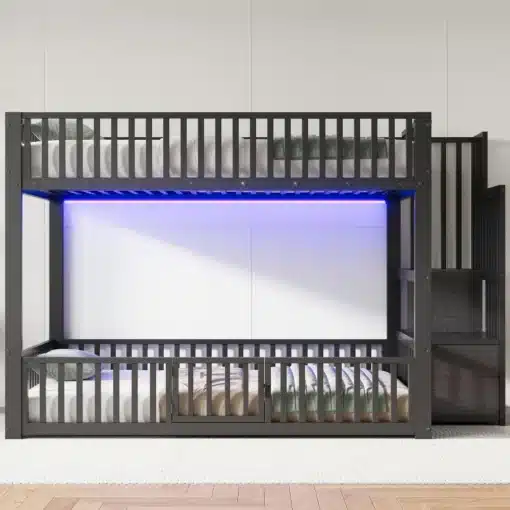 Narivoodi 140×200 cm panipaigaga ja LED valgustusega | E-pood Tootemaailm Kaasaegne narivoodi 140×200 cm panipaigaga ja LED valgustusega, tumehallist metallist raamiga. Voodi tammest värvitud turvapiirete ja integreeritud trepiga, taustal neutraalsed seinad ja hele vaip. Sinine LED valgus süvistatud ülemisse osasse loob stiilse ja rahustava atmosfääri.