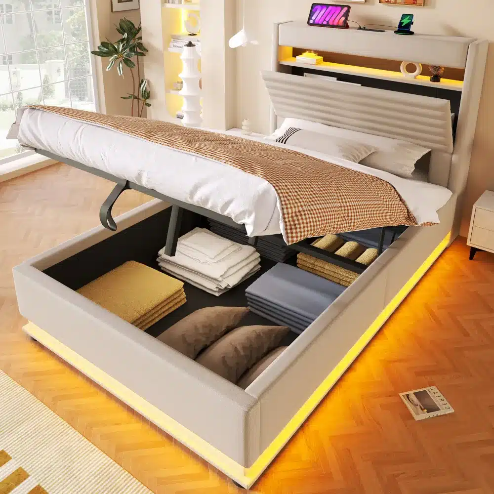 Pesukastiga voodi koos USB-C ja LED valgustusega, mõõtmetega 90x200 cm, hele beeži värvi polsterdus, avatud pesukast nii voodipesu kui ka patjade hoiustamiseks, asub valgusküllases magamistoas puitpõrandaga.