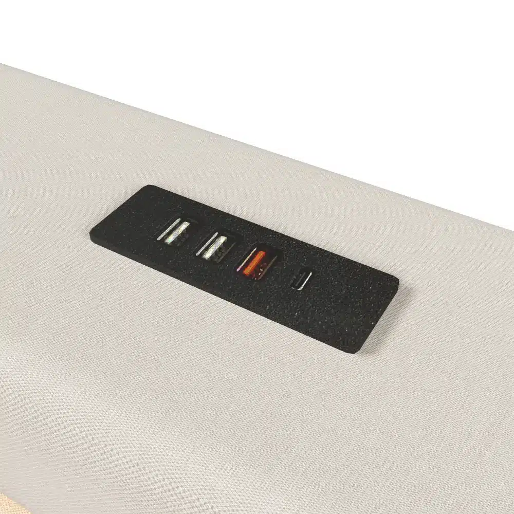 Pesukastiga voodi nurga tõmmis, kus pehmel, heleda kangaga kaetud voodil on näha USB-C ja tavapärased USB-pordid elegantses mustas paneelis.