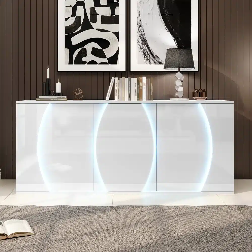 Kõrgläikega disainkummut LED-valgustusega 150 cm, valge, minimalistliku kujundusega, asub stiilses elutoas tumeda puidust seinapaneeli taustal. Kummutit valgustavad peenelt integreeritud LED-tulede kaarjad valgusjooned, mis lisavad kaasaegset elegantsi.