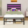 Metallist voodiraam LED valgustuse ja USB laadijaga 90x200 | E-pood Tootemaailm Magamistoas on must metallist voodiraam, mille peaotsas on roosa LED valgustus ja külje peal USB laadija. Voodi on kaetud rohekas voodipesuga, toas on hele puidust põrand ja pehme vaip.