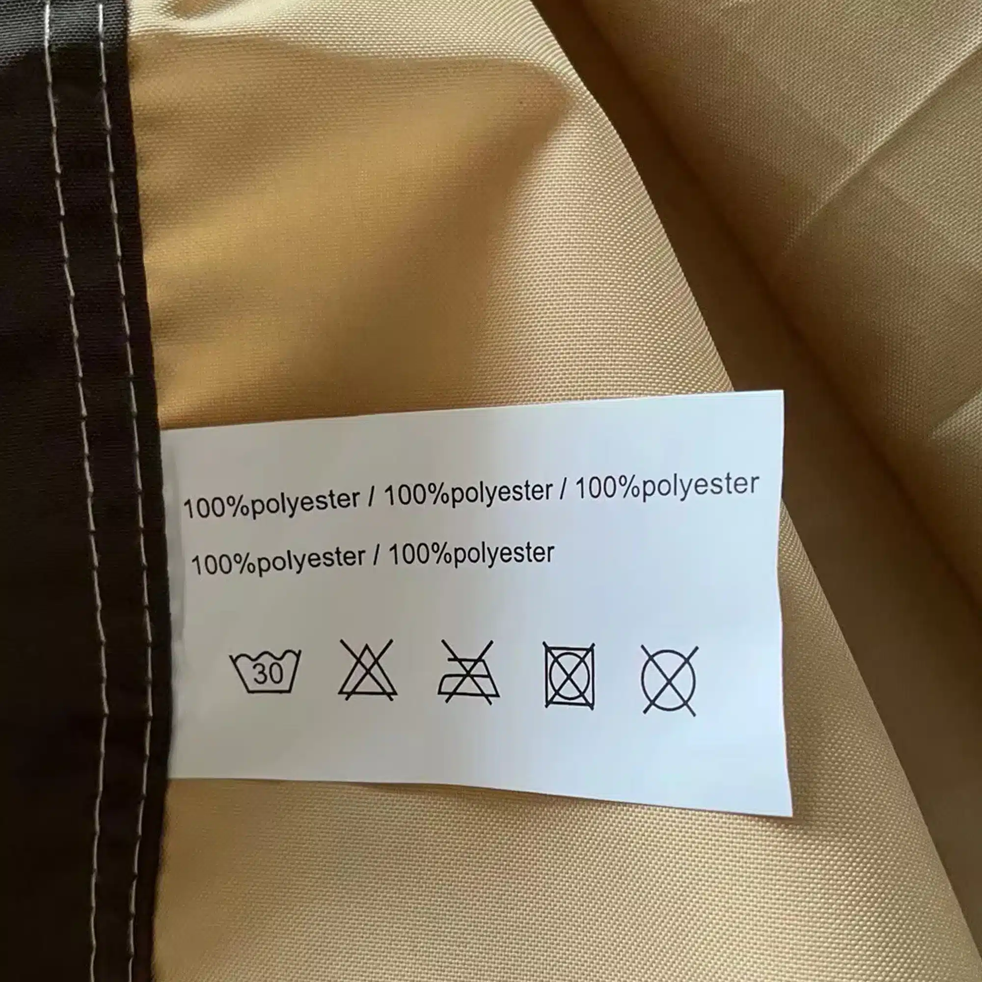 Lähedalt vaade Pergola päikesevarir veekindel UV-kaitsega 12x9 polüestrist kangast ja selle pesemisjuhised heledal pruunil taustal.
