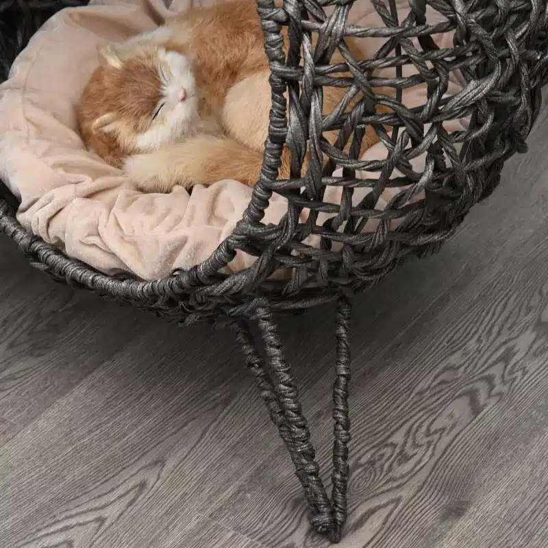 Võluv rotangist pehmendusega kassimaja, hõbehall värv, läbimõõduga 52 cm ja kõrgusega 58 cm. Rotangist raam on tugeval puidust põrandal, kus sees pehme padi ja sellel magav kass.