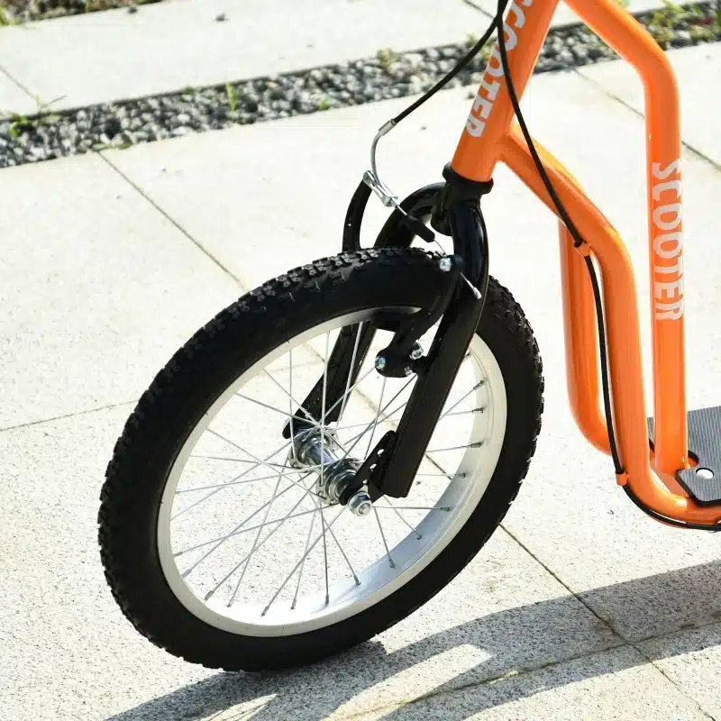 Oranž laste tõukeratas õhkrehvidega, mille esiratas paistab lähedalt. Rattal on sile asfaltist sarnane taust, esile tuues selle tugevdatud musta kahvli ja vastupidava konstruktsiooni.