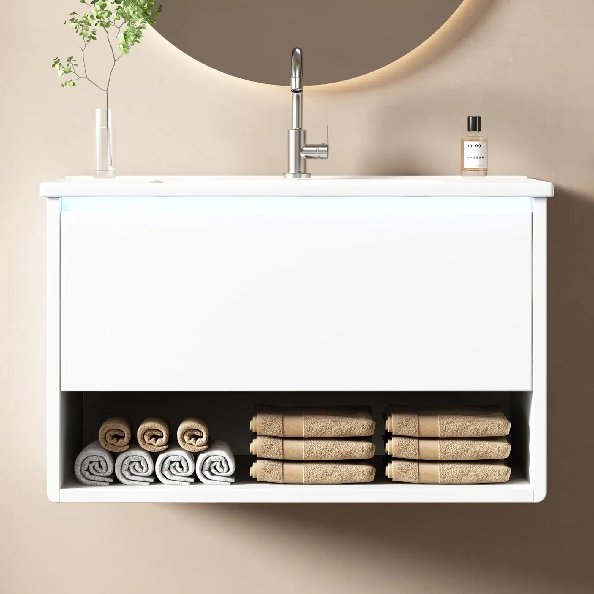 Valge vannitoakapp LED valgustiga ja valamuga, elegantse ja minimalistliku disainiga. Kapi alla on paigutatud rullitud käterätid ning kapi peal on klaasist lillevaas ja parfüümipudel.