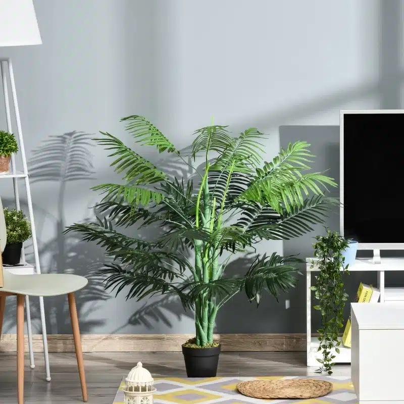 Kaunis Kunstpalm 125 cm kõrguselt potis, roheliste lehtedega dekoratiivtaim, asetsemas heledal elutoa põrandal modernse sisustuse kõrval.
