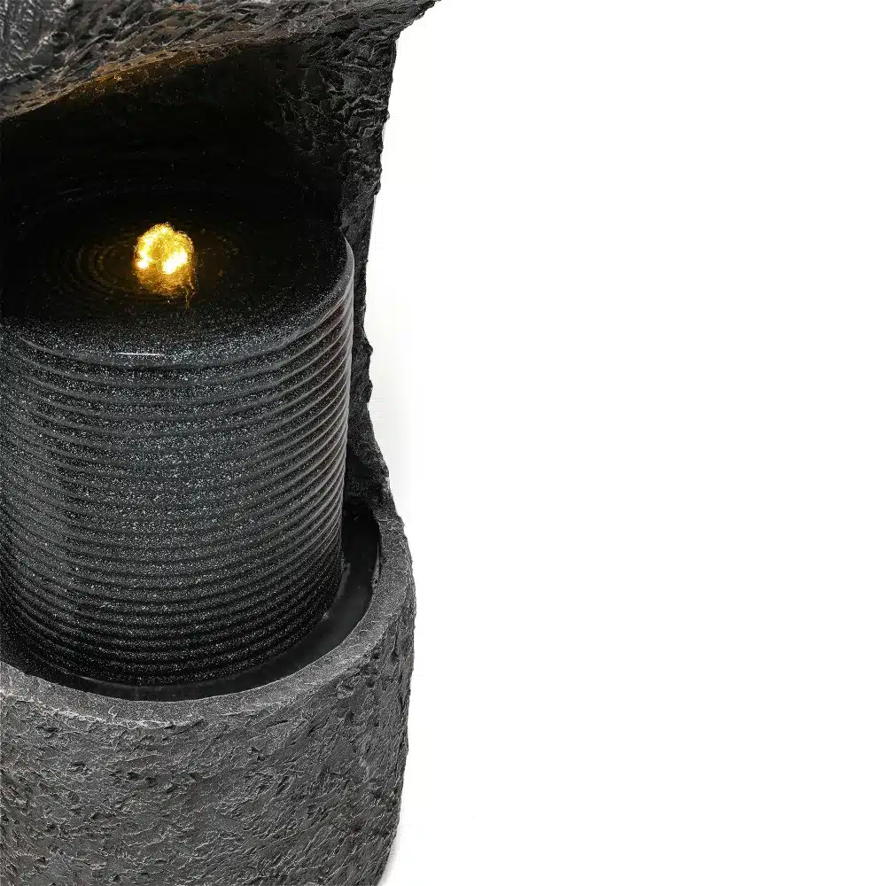 Aia purskkaev LED valgusega, kunstkivi, hall. Pildil on näha hallist kunstkivist purskkaev, millel on särav LED-valgus. Taust on neutraalne, tuues esile purskkaevu detailid.