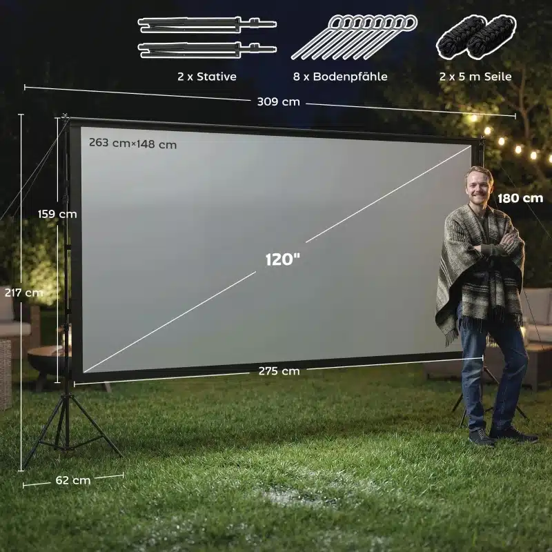 Öine aed, kus on üles seatud 100-tolline 4K kahepoolne projektoriekraan, toetudes mustadele statiividele. Eespool seisab inimene helehallis riietuses. Välisvalgustus ja pimedus loovad hubase atmosfääri.