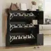 Jalatsikapp 3 klapiga must, istumispingiga, 119x24x122 cm | E-pood Tootemaailm Jalatsikapp 3 klapiga must, istumispingiga, mis mahutab mitmeid kingapaare; kapid on avatud ja täidetud kingadega, taustal hele sein ning mugav diivan.