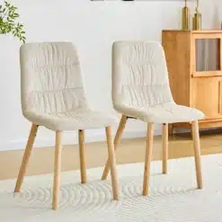 Kaks elegantset söögitooli, millel on kreemjas riidest kangas ja naturaalsed puidust jalad, taustal hele interjöör.
