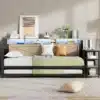 Diivanvoodi must metall 90x200 cm LED valguse ja USB pesaga | E-pood Tootemaailm Stiilne diivanvoodi musta metallraamiga, mõõtmetega 90x200 cm. Voodi on kaunistatud LED valgustusega ja varustatud USB pesaga. Taustal hele sein ja lambanahk efektiga vaip põrandal, endaga harmoneeruvad dekoratiivsed padjad diivanil. Taustal on raamatud ja kaunistused riiulil.