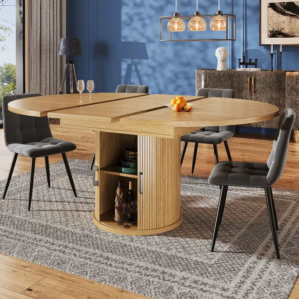 Ümmargune pikendatav söögilaud puidutooni, 6-kohaline, mis sobib suurepäraselt hubasesse söögituppa, heledal puidust põrandal koos hallide toolide ja elegantse valgustiga.