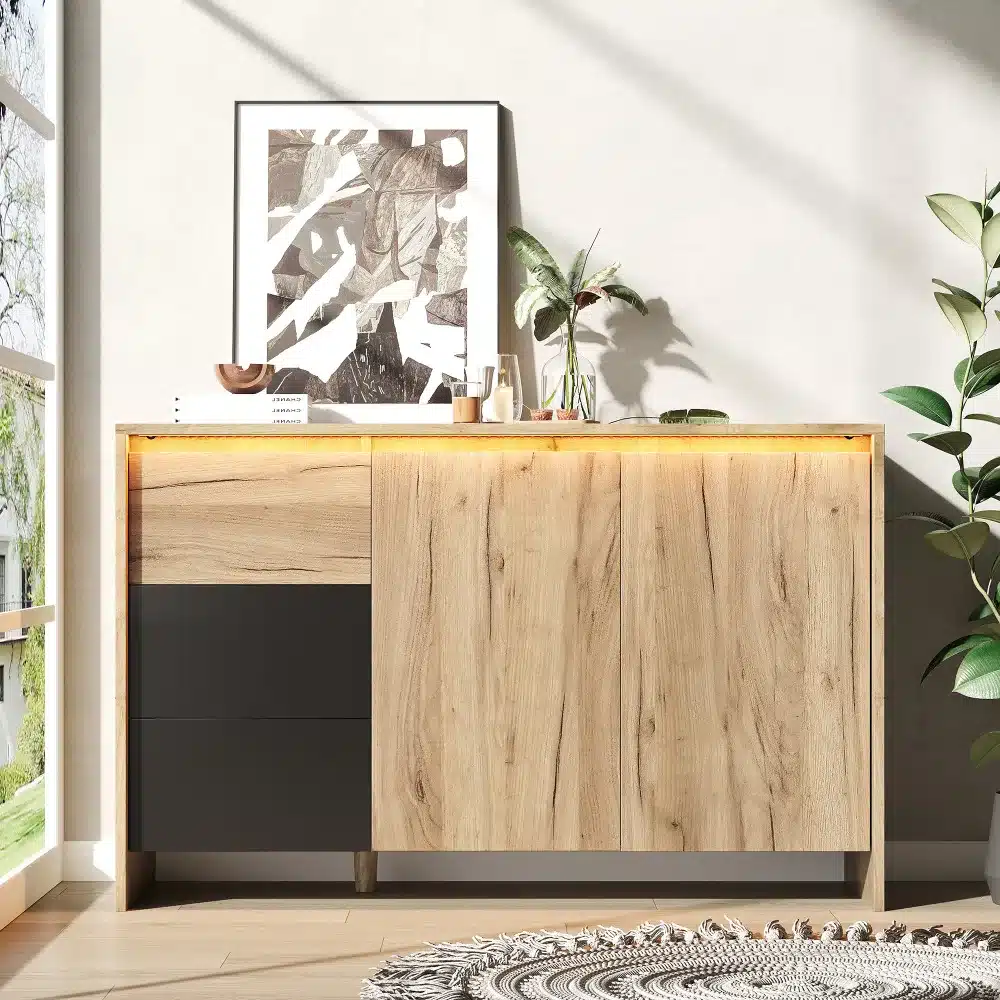 Puidust disain kummut LED valgustusega, valmistatud naturaalsest puidust, asetseb heledal põrandal minimalistikus elutoas. Kummuti mõõtmed on 120x76x40 cm. Tagaseinal abstraktne kunstiteos ja toataime kaunistavad ruumi esteetikat.