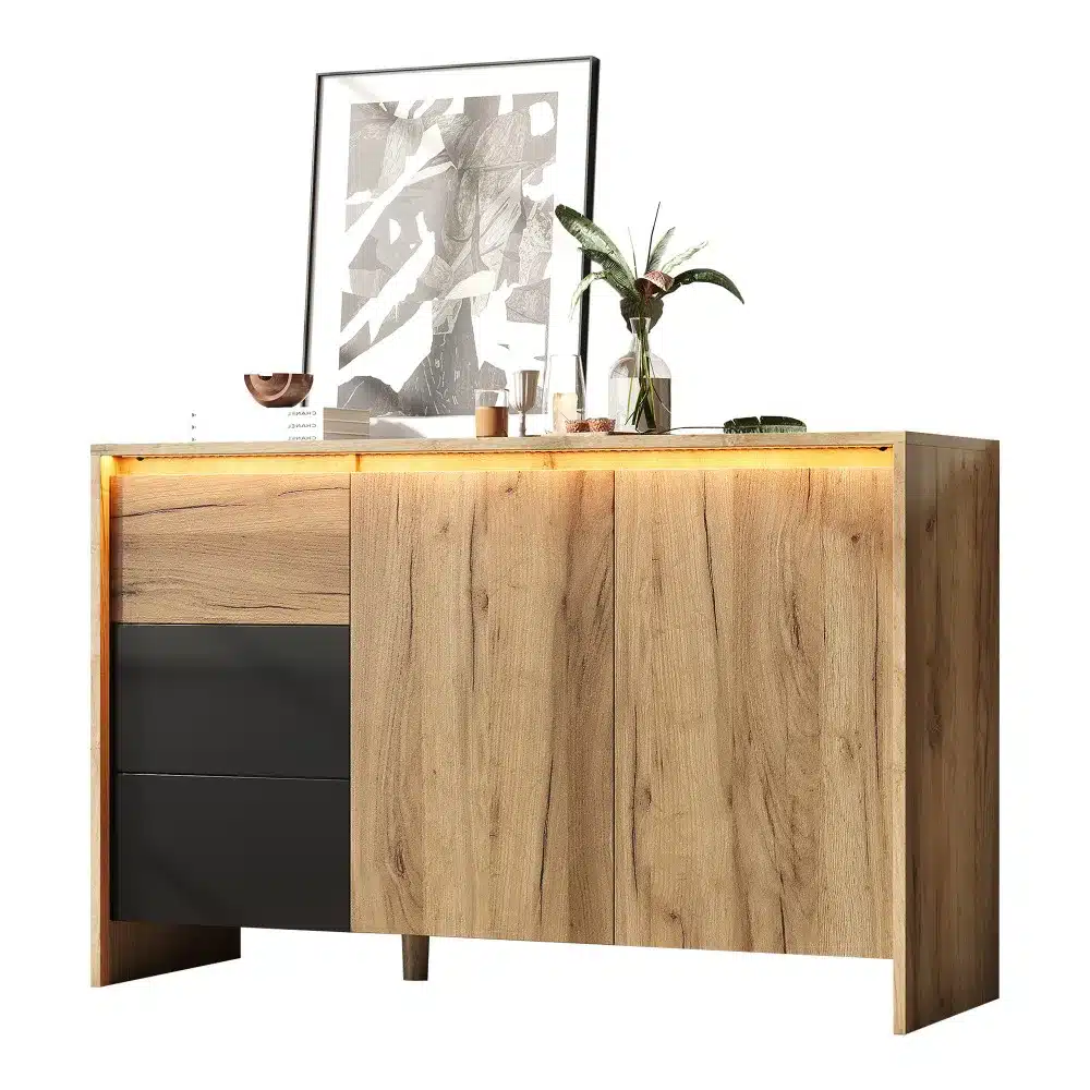 Puidust disain kummut LED valgustusega 120x76x40 cm, hele puit, mustad sahtlid, kaasaegne kunst seina ees ja toataimed pealispinnal.