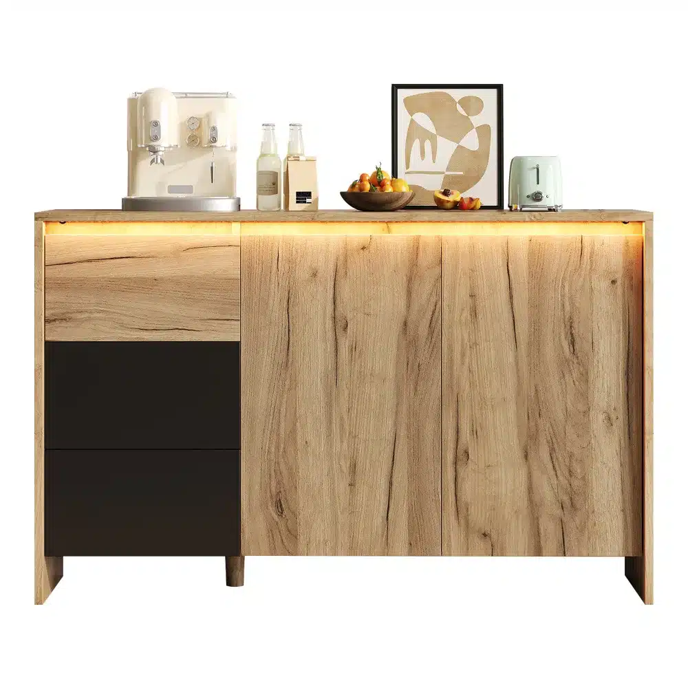 Puidust disain kummut LED valgustusega, mõõtmetega 120x76x40 cm. Kummutil on elegantne hele pruun puitviimistlus ja mustad sahtlid, mis annavad modernse ilme. Seal on peal köögitehnika ja dekoratiivsed esemed, mis loovad stiilse atmosfääri.