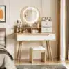 Tualettlaud led-peegli ja polsterdatud tabureti ning sahtlitega | E-pood Tootemaailm Tualettlaud led-peegli ja polsterdatud tabureti ning sahtlitega heledas puidust viimistluses, paigutatud moodsa magamistoa interjööri, koos erinevate kosmeetikatoodetega laual ja sahtlikapis.