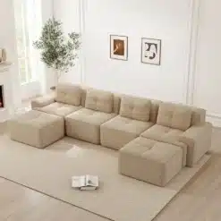 Beež kaasaegne ja praktiline nurgadiivan moodulitest elutoas, hele vaip, suured aknad, valge sein, kunstipildid ja rohelise taime detailid taustal.