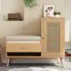 Kingapink rotangist pehmendusega ja avatud sahtlitega | E-pood Tootemaailm Puitviimistlusega kingapink, millel on rotangist uksed, valgest pehmendusega iste ja avatud sahtlid, minimalistlikus esikus valge vaiba taustal.