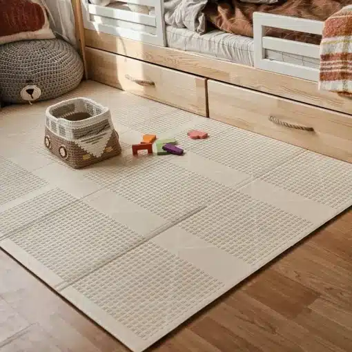 Beige põrandamatt lastetoas voodi ees, korv mänguasjadega ja puidust sahtlid