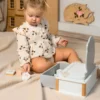 Väikelaps mängib põrandal puidust mänguasjakomplektiga