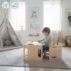 Montessori laud ja tool lastele 3+ | E-pood Tootemaailm Laps istub väikesel puidust lauakombinatsioonil ja joonistab mängutelgi kõrval lastetoas.