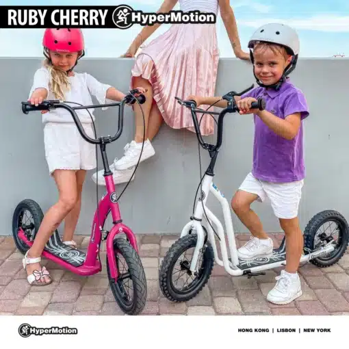 Laste tõukeratas reguleeritava lenksu ja õhkrehvidega | E-pood Tootemaailm Kaks last kiivritega seisavad HyperMotion Ruby Cherry tõukeratastel, üks roosa ja teine valge.