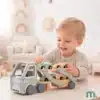 Puidust autoveok 4 autoga lastele 18+ kuud | E-pood Tootemaailm Väike laps mängib puidust autoveoki mänguasjaga, millel on mitu väikest autot.
