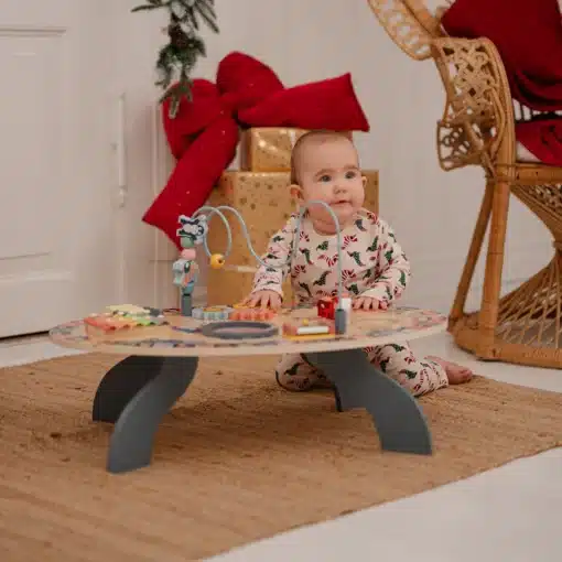 7-ühes õppe- ja muusikalaud Montessori mänguasi | E-pood Tootemaailm Beebi mängib madala puidust tegevuslaua juures koduses toas
