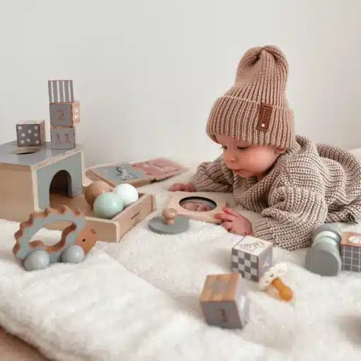 Montessori arendav puidust mängukomplekt beebile 6 tk | E-pood Tootemaailm Beebis mängib pehmel vaibal puidust arendusmänguasjadega ja kannab kootud mütsi