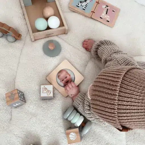 Montessori arendav puidust mängukomplekt beebile 6 tk | E-pood Tootemaailm Beebi mängib pehmel tekil puidust mänguasjadega, kõrval näha tähestiku- ja kujundiplokid