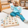 Montessori kalapüügi mäng lastele | E-pood Tootemaailm Laps mängib puidust kuulimänguga ja hoiab sinist palli käes