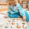 Montessori kalapüügi mäng lastele | E-pood Tootemaailm Laps mängib puidust sorteerimislauaga, asetades värvilisi mune aukudesse