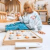 Montessori kalapüügi mäng lastele | E-pood Tootemaailm Väike laps mängib põrandal puidust sorteerimismänguga, millel on munakujulised osad.