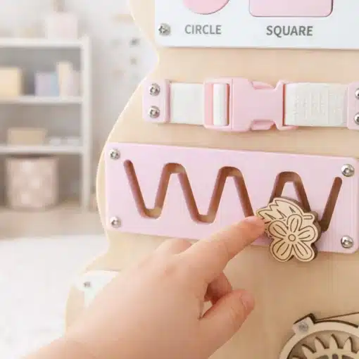 Montessori puidust sensoorne tegevustahvel lastele | E-pood Tootemaailm Laps puudutab puidust tegevuslaua lillekujundit roosal mänguelemendil