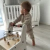 Puidust käimistugi ja õppelaud 6 in 1 lastele | E-pood Tootemaailm Väikelaps seisab ja hoiab kinni puidust tegevusmänguasjast toa põrandal